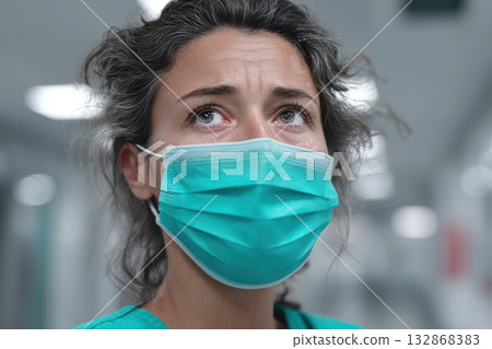 Smiling behind a mask, a medical worker reflects resilience in a hospital setting 132868383