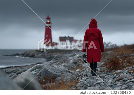Keeper walks along rocky shore towards lighthouse under cloudy sky Keeper walks along rocky shore towards lighthouse under cloudy sky 132868420