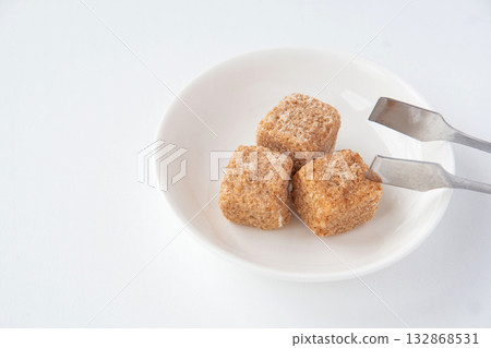 Brown sugar on a white plate 132868531
