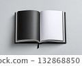 Open book with blank black pages resting on a neutral backdrop during daylight hours 132868850