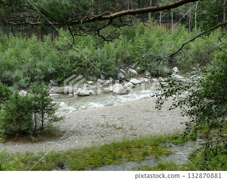 A stream of clear water from the high mountains continues its movement over the rocks like a mountain stream. 132870881