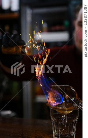 Bartender making a fire flame cocktail in elegant night club party unique experience - Alcoholic drinks Close up.  132871387
