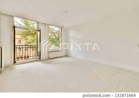 A bright and spacious interior featuring a large open window that allows natural light to flow in. The room showcases a minimalist design with white walls and floor. A bright and spacious interior featuring a large open window that allows natural light to flow in. The room showcases a minimalist design with white walls and floor. 132871669