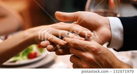 She Said Yes. Unrecognizable Man Putting Engagement Ring On Girfriend's Finger After Romantic Proposal In Restaurant, Selective Focus She Said Yes. Unrecognizable Man Putting Engagement Ring On Girfriend's Finger After Romantic Proposal In Restaurant, Selective Focus 132871970