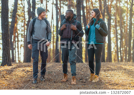 Active young mixed race people backpacking at countryside, having conversation while walking Active young mixed race people backpacking at countryside, having conversation while walking 132872007