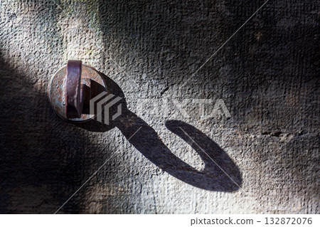 Metal hooks create unique light and shadow effects on the stone wall. Metal hooks create unique light and shadow effects on the stone wall. 132872076