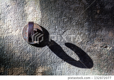 Metal hooks create unique light and shadow effects on the stone wall. 132872077