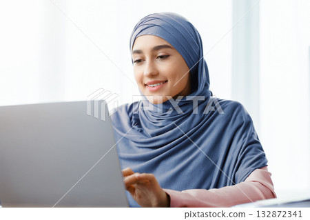 Closeup Portrait Of Saudi Businesswoman Working On Laptop Computer In Office, Selective Focus, Free Space Closeup Portrait Of Saudi Businesswoman Working On Laptop Computer In Office, Selective Focus, Free Space 132872341