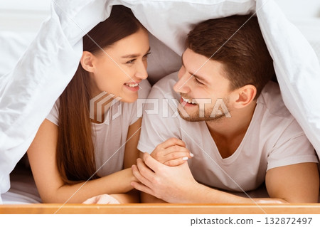 Couple Relatioship. Happy Boyfriend And Girlfriend Lying On Bed Covered With Blanket In Bedroom. Selective Focus 132872497