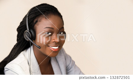 Hotline operator. Portrait of beautiful black female customer service manager wearing headset while working in call center Hotline operator. Portrait of beautiful black female customer service manager wearing headset while working in call center 132872501
