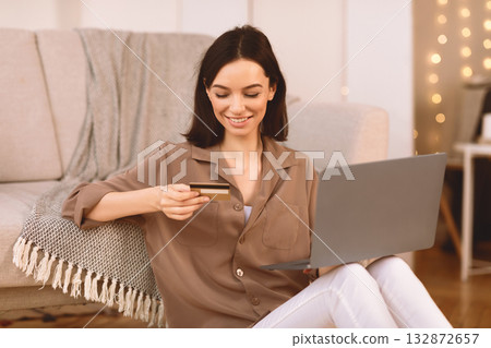 Joyful European Girl Doing Online Shopping Using Laptop Computer And Credit Card Sitting On The Floor. Copyspace 132872657
