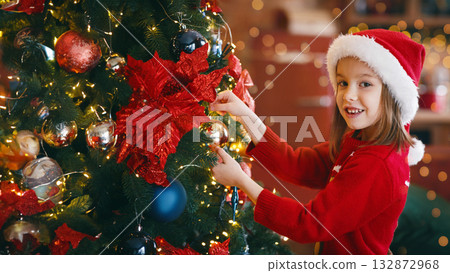 Adorable little girl decorating Christmas tree with colorful glass bubbles at home Adorable little girl decorating Christmas tree with colorful glass bubbles at home 132872968