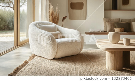 A stylish living room showcases a plush, rounded chair alongside a simple wooden table A stylish living room showcases a plush, rounded chair alongside a simple wooden table 132873405