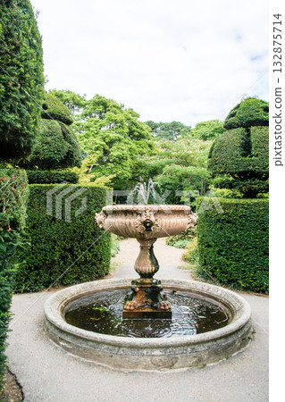 A small, historic fountain in a well-maintained garden under a bright sky in Nyman Park, on the outskirts of London A small, historic fountain in a well-maintained garden under a bright sky in Nyman Park, on the outskirts of London 132875714