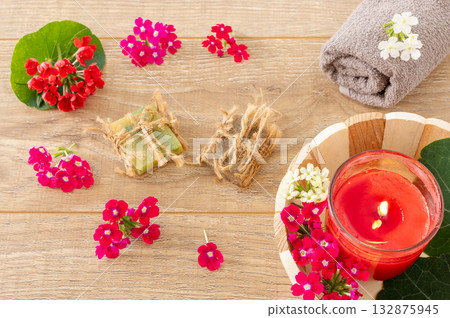 Towel with body care products and verbena flowers on the wooden background. Towel with body care products and verbena flowers on the wooden background. 132875945