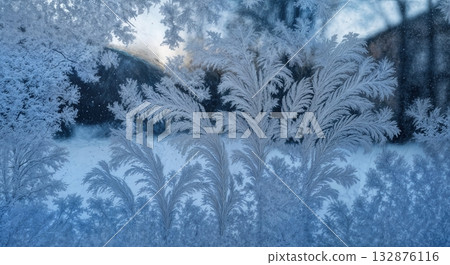 Delicate Frost Patterns on Windowpane Close-up with Backlit Ice Crystal Details and Winter Scene Delicate Frost Patterns on Windowpane Close-up with Backlit Ice Crystal Details and Winter Scene 132876116