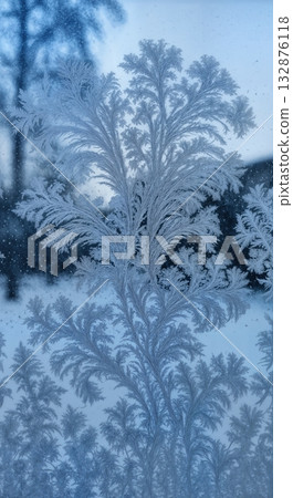 Delicate Frost Patterns on Windowpane Close-up with Backlit Ice Crystal Details and Winter Scene 132876118