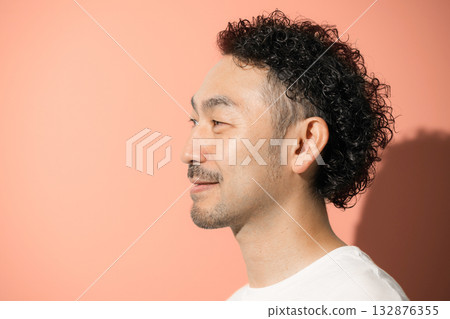 Close-up of a middle-aged man's profile against an orange background 132876355