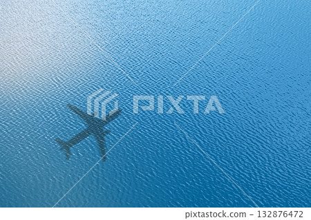 Concept of airplane travel. Airplane shadow on blue water. 132876472