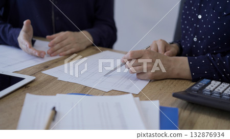 Accountants or auditors reviewing financial documents while sitt Accountants or auditors reviewing financial documents while sitt 132876934