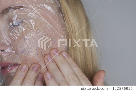 Microplastics in cosmetics. A woman applied a care cream to her skin, now it is covered with plastic particles and microbeads. Cosmetics toxicity concept 132876935