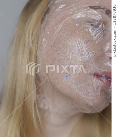 Microplastics in cosmetics. A woman applied a care cream to her skin, now it is covered with plastic particles and microbeads. Cosmetics toxicity concept Microplastics in cosmetics. A woman applied a care cream to her skin, now it is covered with plastic particles and microbeads. Cosmetics toxicity concept 132876936