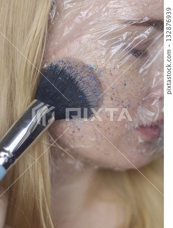 Microplastics in cosmetics. A woman applied a care cream to her skin, now it is covered with plastic particles and microbeads. Cosmetics toxicity concept Microplastics in cosmetics. A woman applied a care cream to her skin, now it is covered with plastic particles and microbeads. Cosmetics toxicity concept 132876939