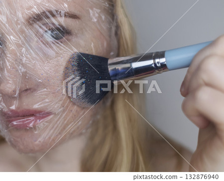 Microplastics in cosmetics. A woman applied a care cream to her skin, now it is covered with plastic particles and microbeads. Cosmetics toxicity concept 132876940