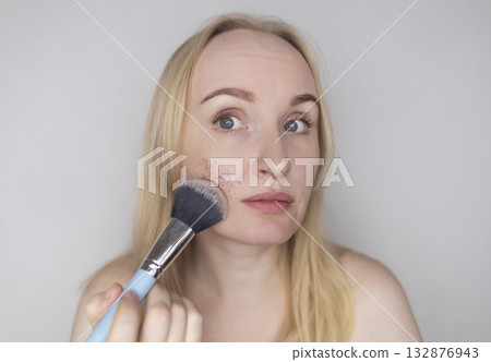 Microplastics in cosmetics. A woman applied a care cream to her skin, now it is covered with plastic particles and microbeads. Cosmetics toxicity concept 132876943