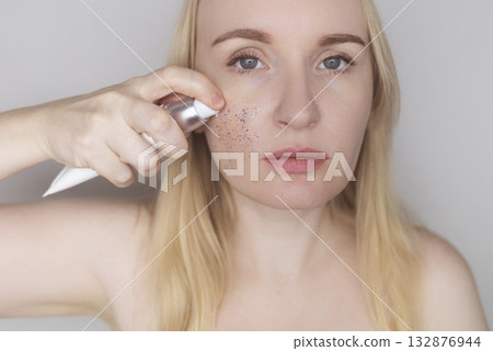 Microplastics in cosmetics. A woman applied a care cream to her skin, now it is covered with plastic particles and microbeads. Cosmetics toxicity concept 132876944