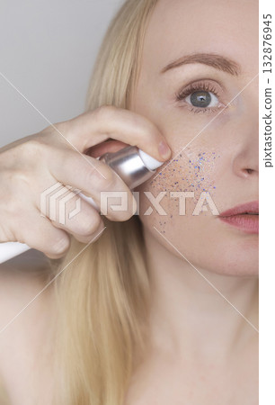 Microplastics in cosmetics. A woman applied a care cream to her skin, now it is covered with plastic particles and microbeads. Cosmetics toxicity concept 132876945