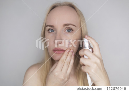 Microplastics in cosmetics. A woman applied a care cream to her skin, now it is covered with plastic particles and microbeads. Cosmetics toxicity concept 132876946