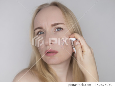 Microplastics in cosmetics. A woman applied a care cream to her skin, now it is covered with plastic particles and microbeads. Cosmetics toxicity concept 132876950