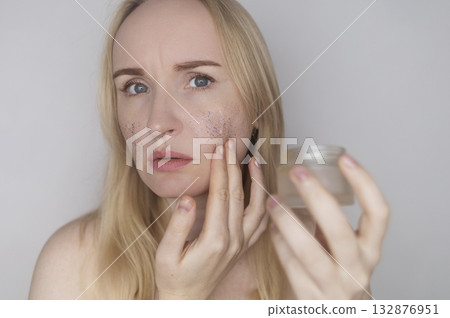 Microplastics in cosmetics. A woman applied a care cream to her skin, now it is covered with plastic particles and microbeads. Cosmetics toxicity concept Microplastics in cosmetics. A woman applied a care cream to her skin, now it is covered with plastic particles and microbeads. Cosmetics toxicity concept 132876951