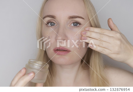 Microplastics in cosmetics. A woman applied a care cream to her skin, now it is covered with plastic particles and microbeads. Cosmetics toxicity concept Microplastics in cosmetics. A woman applied a care cream to her skin, now it is covered with plastic particles and microbeads. Cosmetics toxicity concept 132876954