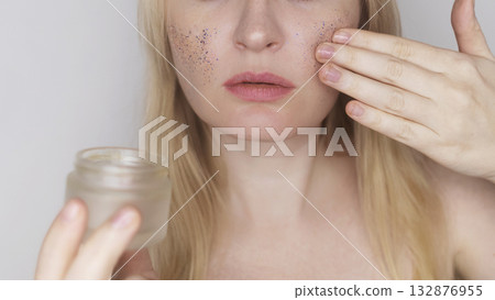 Microplastics in cosmetics. A woman applied a care cream to her skin, now it is covered with plastic particles and microbeads. Cosmetics toxicity concept Microplastics in cosmetics. A woman applied a care cream to her skin, now it is covered with plastic particles and microbeads. Cosmetics toxicity concept 132876955