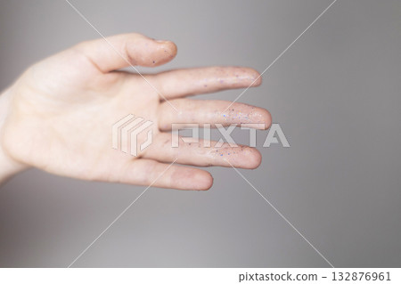 Microplastics in cosmetics. A woman applied a care cream to her skin, now it is covered with plastic particles and microbeads. Cosmetics toxicity concept Microplastics in cosmetics. A woman applied a care cream to her skin, now it is covered with plastic particles and microbeads. Cosmetics toxicity concept 132876961