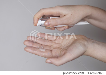 Microplastics in cosmetics. A woman applied a care cream to her skin, now it is covered with plastic particles and microbeads. Cosmetics toxicity concept 132876963