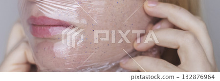 Microplastics in cosmetics. A woman applied a care cream to her skin, now it is covered with plastic particles and microbeads. Cosmetics toxicity concept 132876964