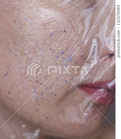 Microplastics in cosmetics. A woman applied a care cream to her skin, now it is covered with plastic particles and microbeads. Cosmetics toxicity concept 132876965