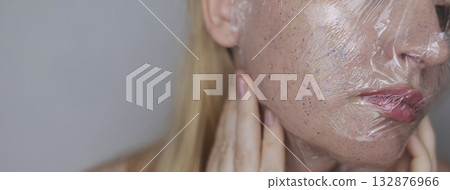Microplastics in cosmetics. A woman applied a care cream to her skin, now it is covered with plastic particles and microbeads. Cosmetics toxicity concept Microplastics in cosmetics. A woman applied a care cream to her skin, now it is covered with plastic particles and microbeads. Cosmetics toxicity concept 132876966