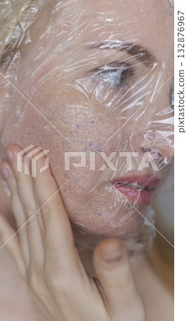 Microplastics in cosmetics. A woman applied a care cream to her skin, now it is covered with plastic particles and microbeads. Cosmetics toxicity concept 132876967