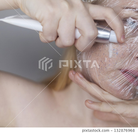 Microplastics in cosmetics. A woman applied a care cream to her skin, now it is covered with plastic particles and microbeads. Cosmetics toxicity concept Microplastics in cosmetics. A woman applied a care cream to her skin, now it is covered with plastic particles and microbeads. Cosmetics toxicity concept 132876968