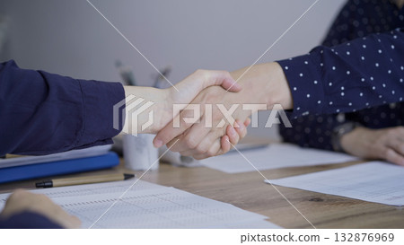 Accountants or auditors shaking hands after reviewing financial Accountants or auditors shaking hands after reviewing financial 132876969