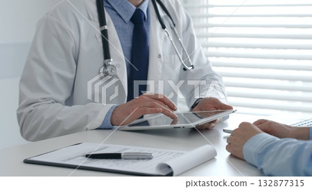 Medical practitioner sharing information with patient on a digital tablet during consultation, enhancing communication in healthcare. Medicine and health care concept Medical practitioner sharing information with patient on a digital tablet during consultation, enhancing communication in healthcare. Medicine and health care concept 132877315