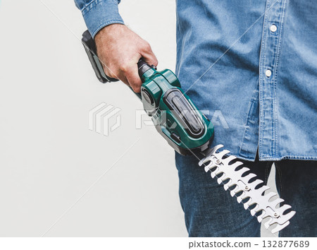 Handsome man, work clothes and hedge trimmer 132877689