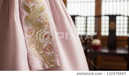 Pink silk fabric with intricate golden phoenix bird and floral embroidery detail close-up shot in traditional asian style Pink silk fabric with intricate golden phoenix bird and floral embroidery detail close-up shot in traditional asian style 132878847