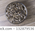 Striped sunflower seeds in a glass bowl on a wooden table. 132879536