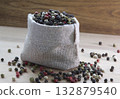Mixture colored peppers in a canvas sack on wooden kitchen table. 132879540