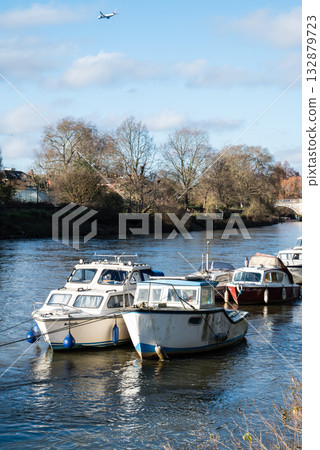 在倫敦郊區里士滿，泰晤士河上停泊著沐浴在明媚陽光下的船隻。 132879723